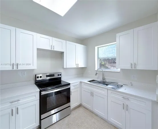 a kitchen with cabinets appliances and a window