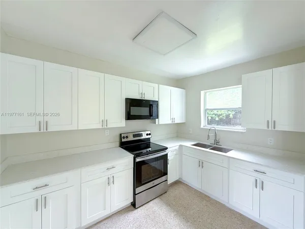 a kitchen with white cabinets and white appliances