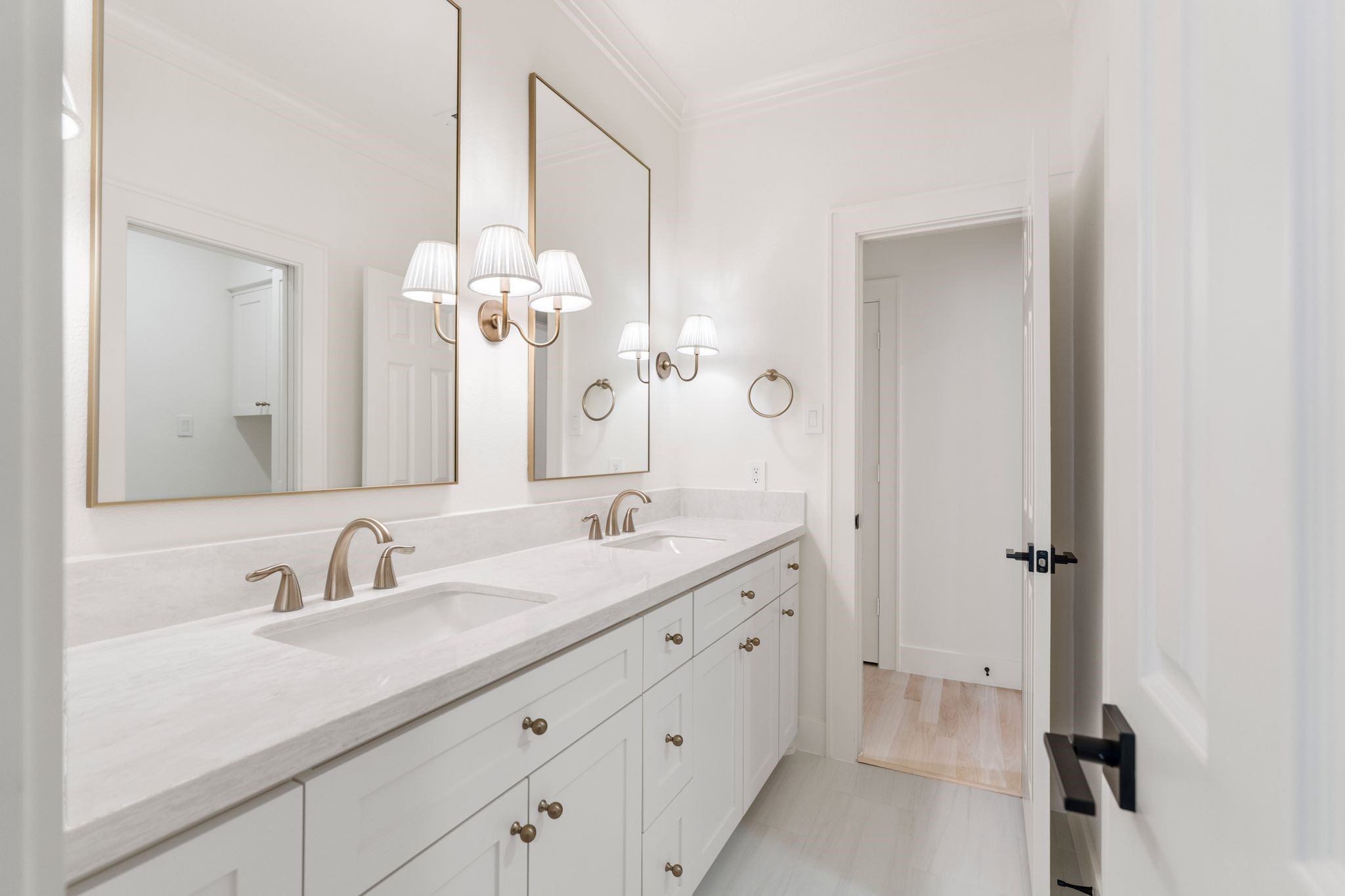 31 Hollymead Drive Spring, TX 77381 - Photo 36 of 50 This bathroom features a double vanity with elegant fixtures, large mirrors, and soft lighting. The clean, white cabinetry offers ample storage, creating a bright and inviting space.