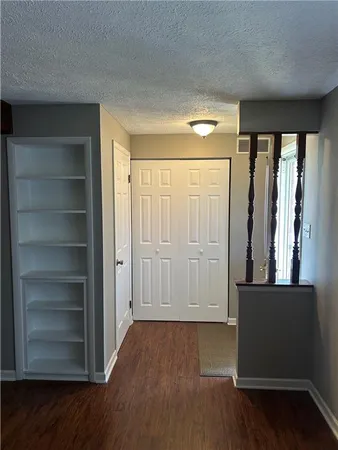 a view of a hallway with wooden floor and closet