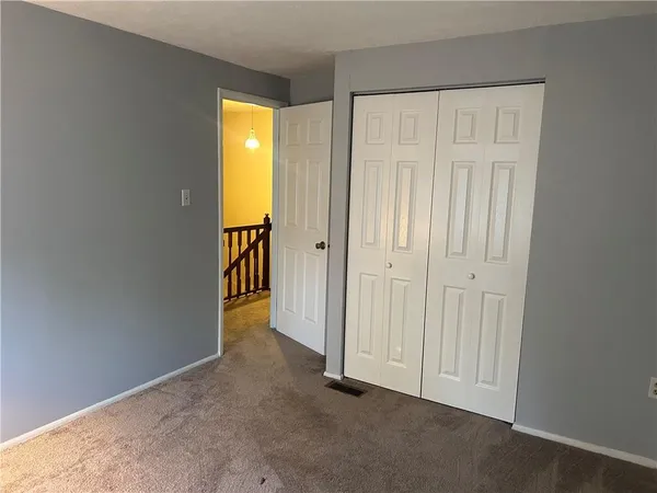 an empty room with wooden floor and closet area