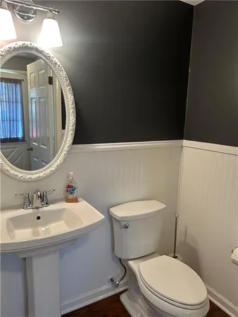 a bathroom with a toilet a sink and mirror