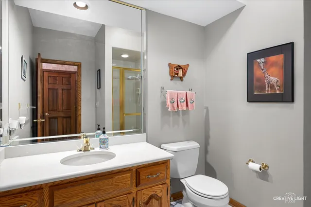 a bathroom with a granite countertop toilet a sink and a mirror