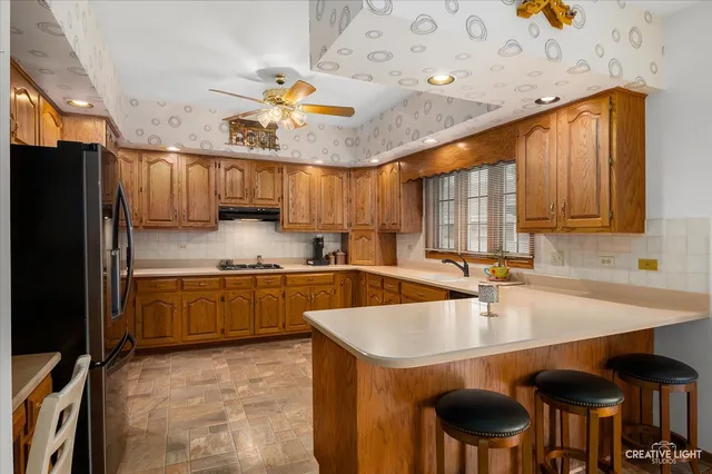 a kitchen with stainless steel appliances granite countertop a sink refrigerator and cabinets