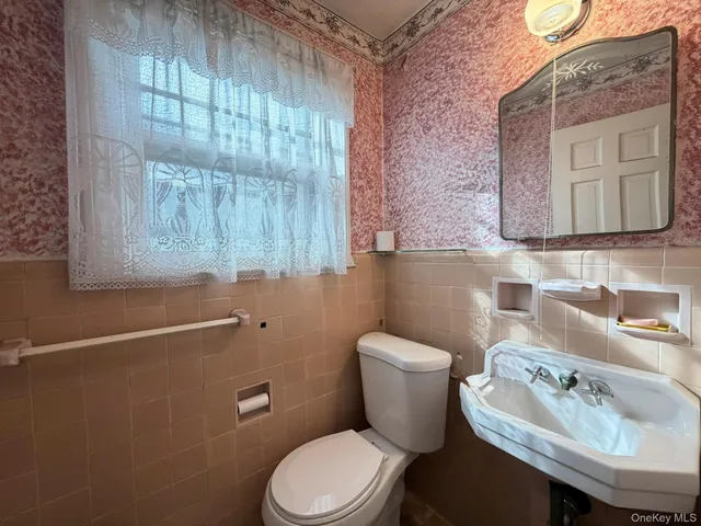 a white toilet sitting next to a bathroom sink