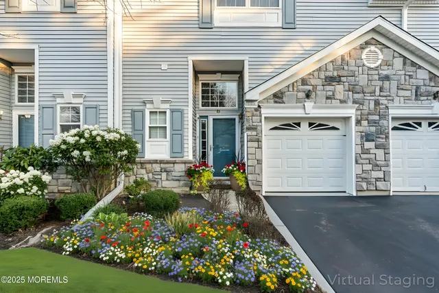 a front view of a house with a yard and potted plants