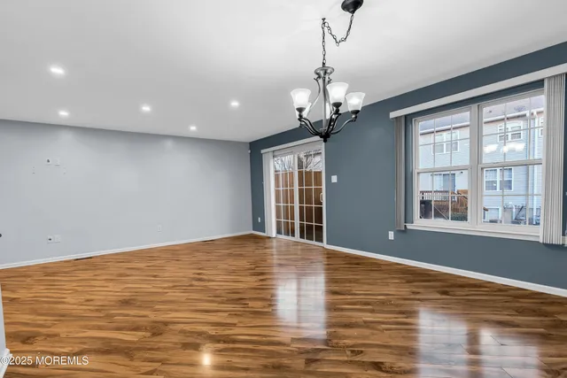 a kitchen with stainless steel appliances kitchen island granite countertop a table chairs stove and refrigerator