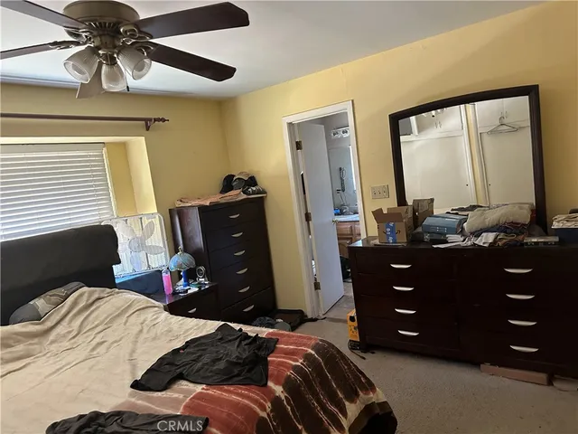a bedroom with a bed and a mirror on dresser
