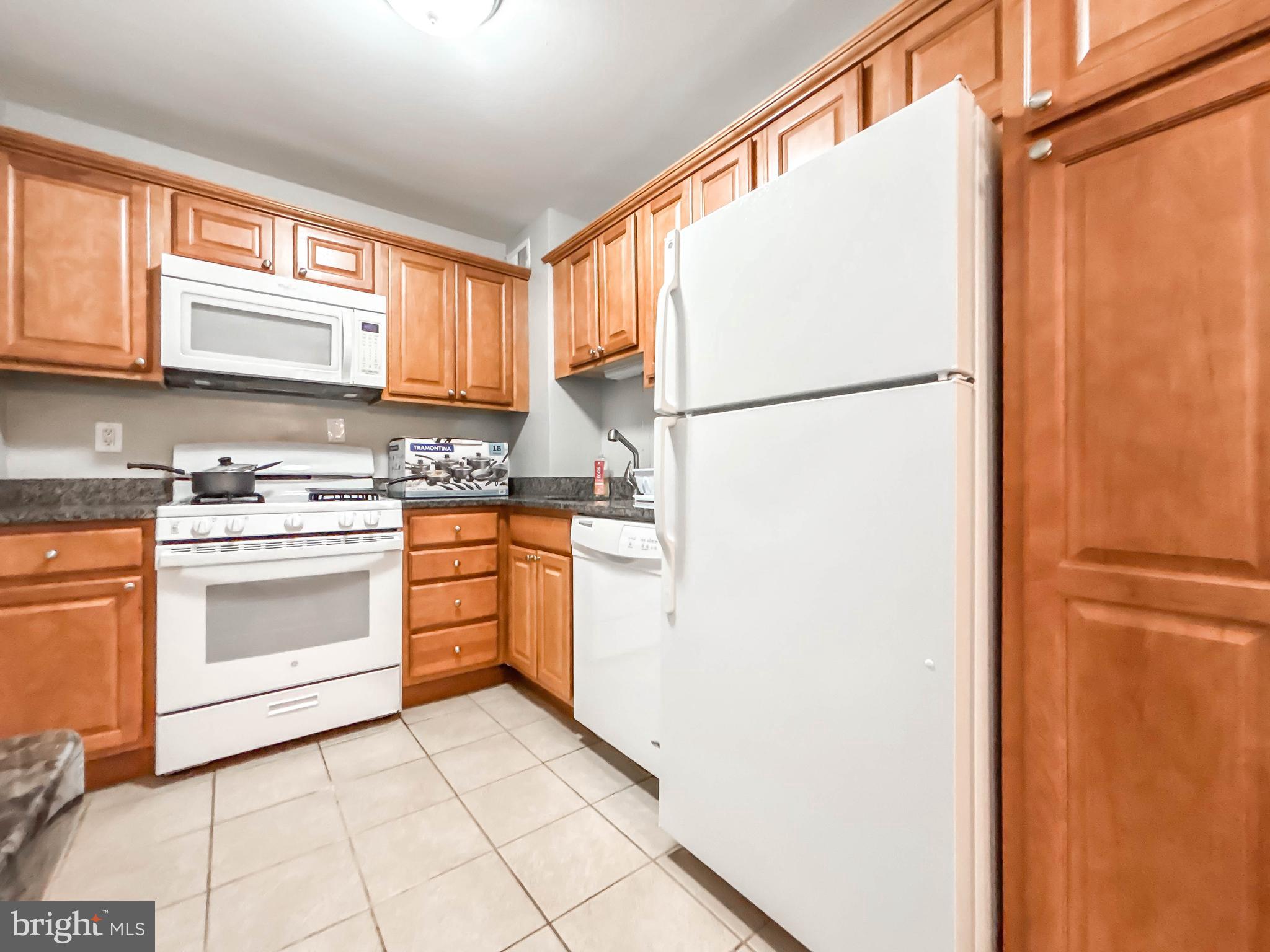 130 Slade Avenue, Unit 414 Baltimore, MD 21208 - Photo 40 of 48 a kitchen with white cabinets and white appliances