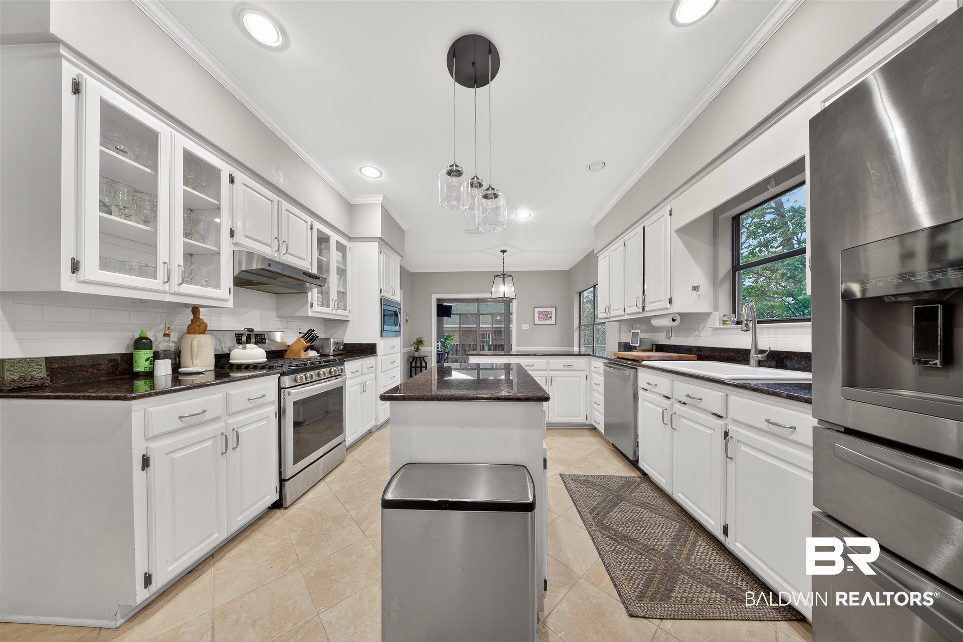 1250 Savannah Drive Mobile, AL 36609 - Photo 16 of 35 Kitchen featuring stainless steel appliances, white cabinetry, and crown molding