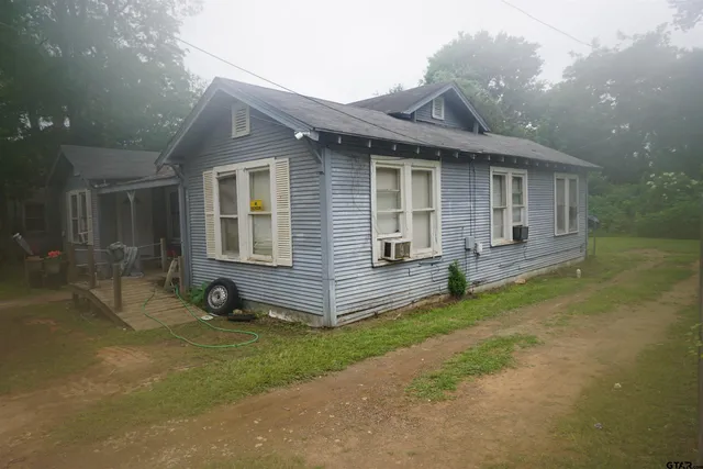 a view of a house with a yard and sitting area