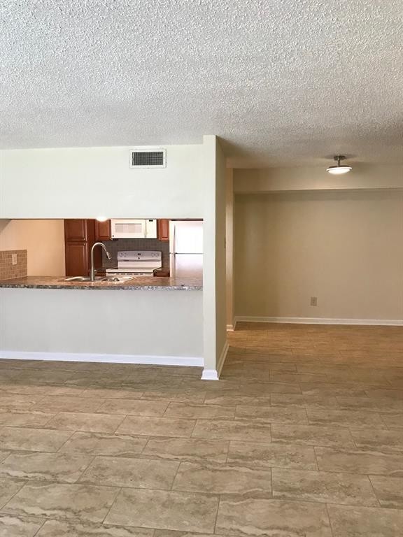 1947 Greenbriar Colony Drive, Unit 15518C Houston, TX 77032 - Photo 7 of 12 a view of a refrigerator in an empty room
