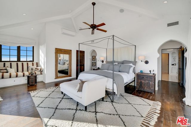 a kitchen with granite countertop a refrigerator a stove a sink a dining table and chairs with wooden floor