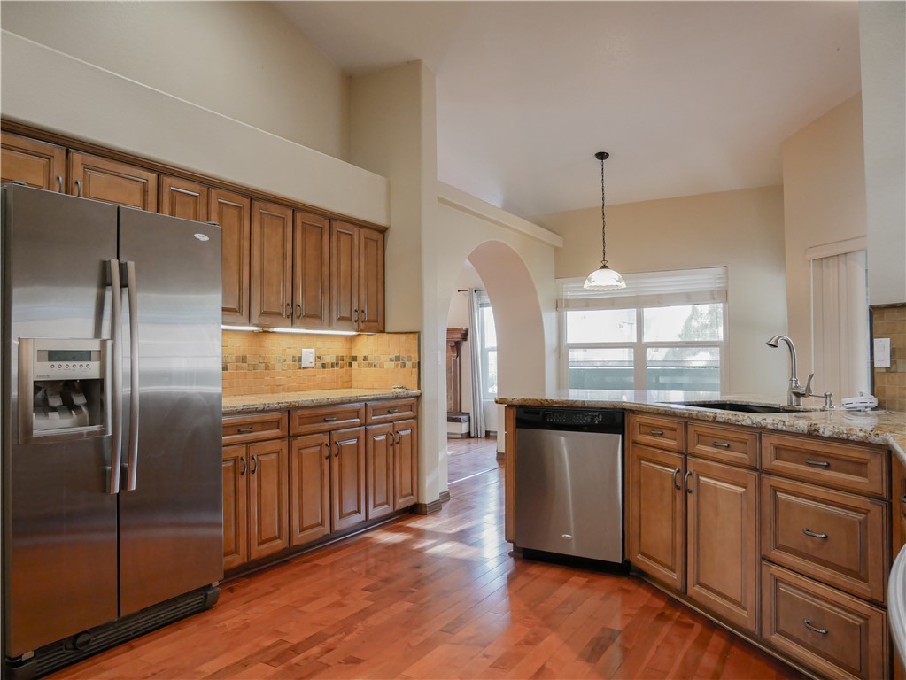 2575 Triangle S Street Kingman, AZ 86401 - Photo 11 of 45 a kitchen with stainless steel appliances granite countertop a refrigerator a sink dishwasher a stove and white countertops with wooden floor