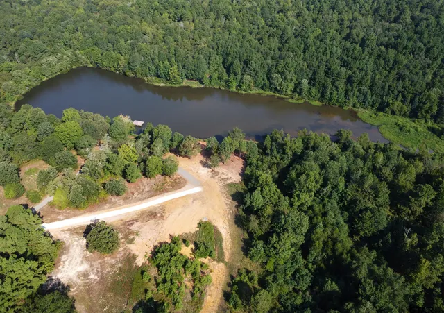 an aerial view of a house with a yard and lake view