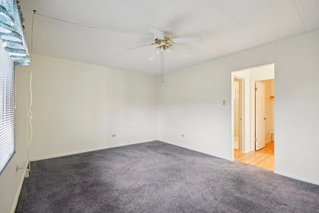 an empty room with a ceiling fan and a window