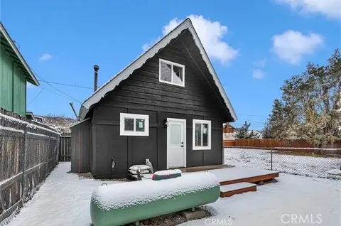 a living room with furniture wooden floor and a kitchen view