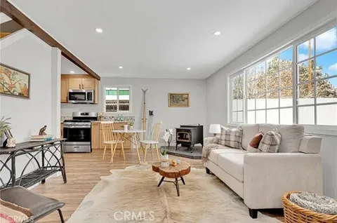 a kitchen with stainless steel appliances a dining table chairs refrigerator and sink