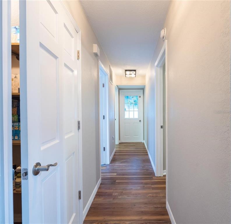 13219 Tyrone Street Hudson, FL 34667 - Photo 26 of 99 a view of a hallway with wooden floor and a bathroom