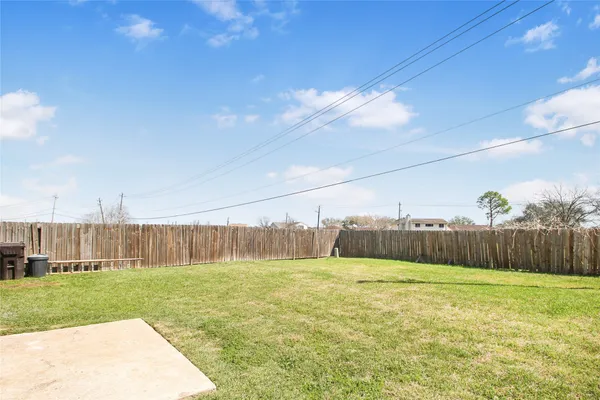 a view of a swimming pool with a big yard and a large tree