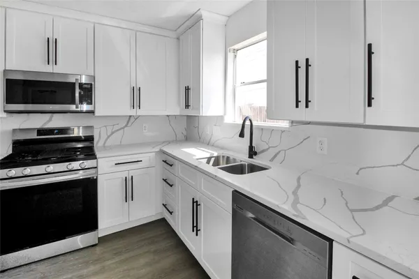 a kitchen with a sink stove and microwave