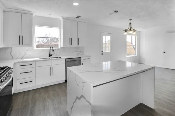 a kitchen with a sink a stove and cabinets
