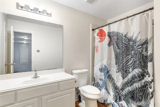 a bathroom with a toilet sink and shower curtain