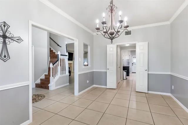 a view of a hallway with a chandelier and dining area