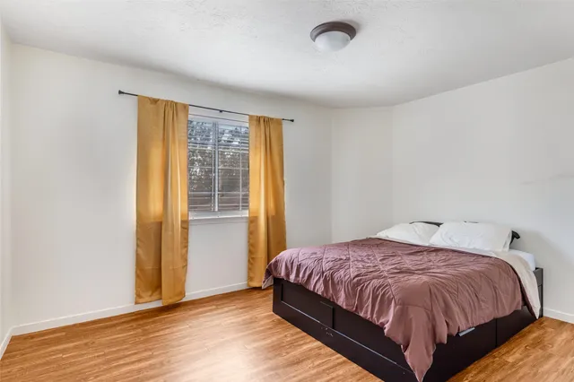 a bedroom with a bed and wooden floor