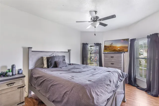 a bedroom with a large bed and a flat tv screen on dresser