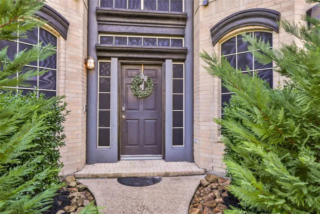 a view of a door of the house with potted plants