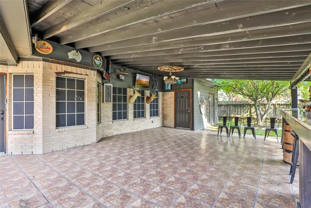 a view of a porch with a table and chairs under an umbrella