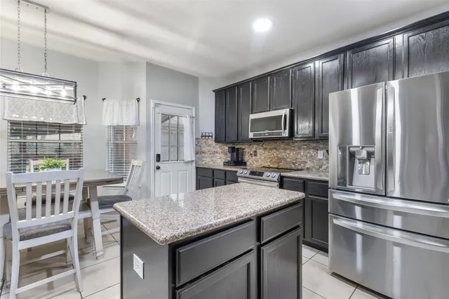 a kitchen with a refrigerator and a stove top oven