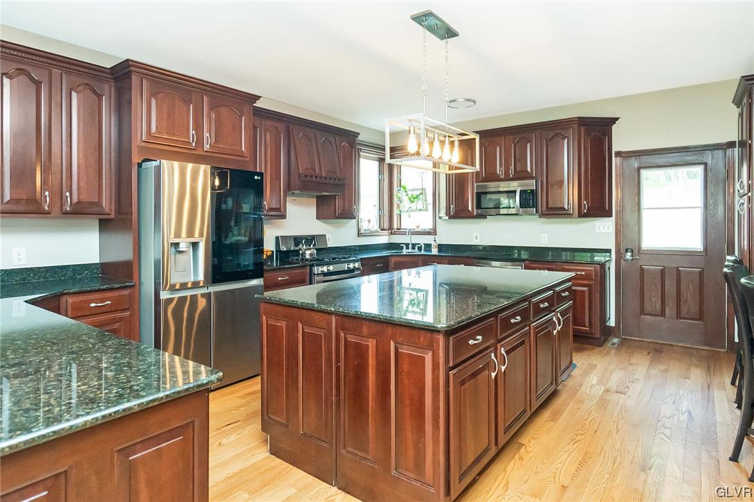 870 Stagecoach Road West Lehighton, PA 18235 - Photo 22 of 50 a kitchen with stainless steel appliances granite countertop a stove a sink dishwasher oven and a refrigerator with wooden cabinets