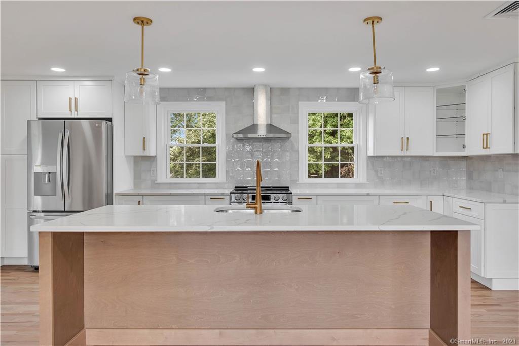 a large kitchen with kitchen island a large counter top space appliances and cabinets