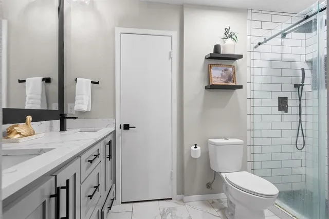 a bathroom with a sink a toilet and shower