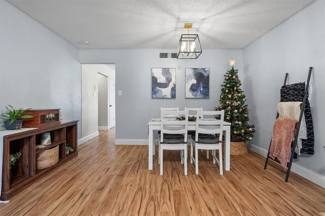 a dining room with furniture a chandelier and wooden floor