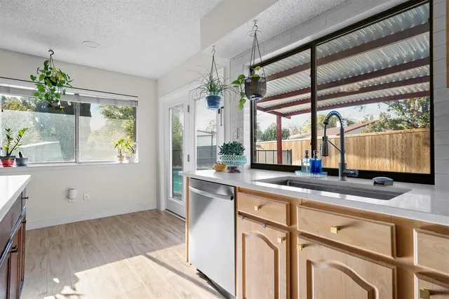 a kitchen with stainless steel appliances double cabinets and a large window