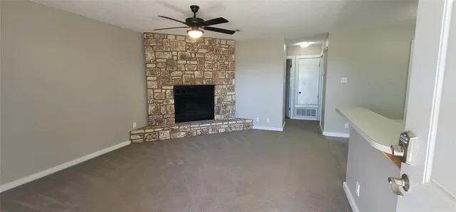 a view of an empty room with a fireplace and a window