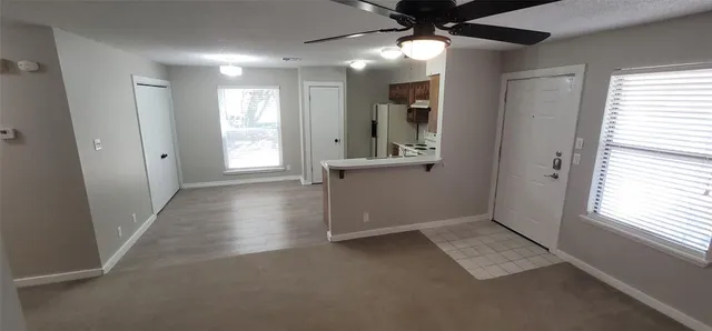 a view of an empty room with window and cabinet