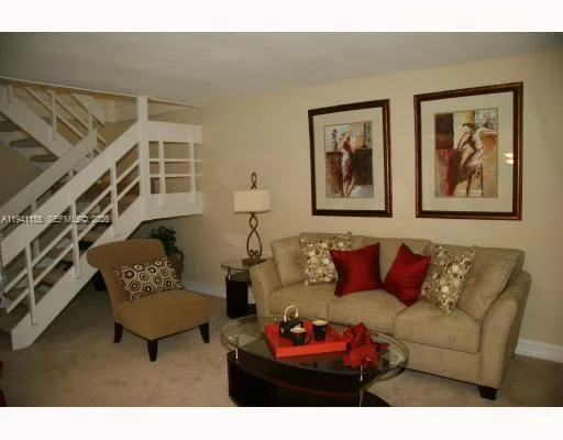 a living room with furniture and a potted plant
