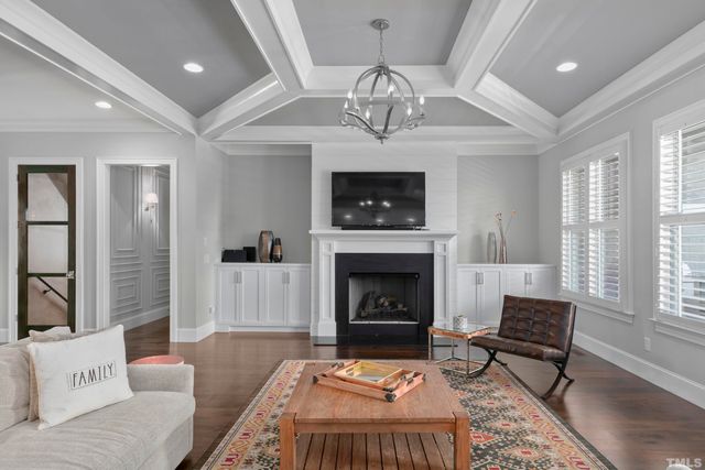 a living room with furniture a chandelier and a fireplace