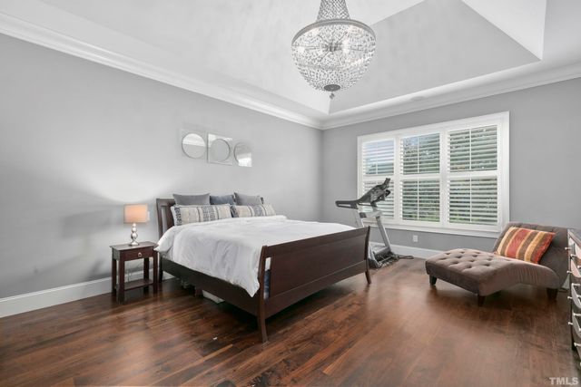 a spacious bedroom with a bed and a chandelier