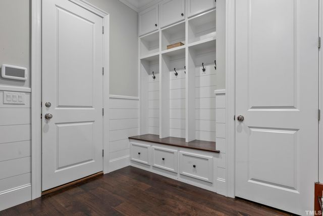a view of an empty room with wooden floor and closet