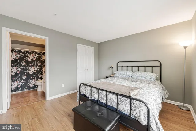 a bedroom with a bed and wooden floor