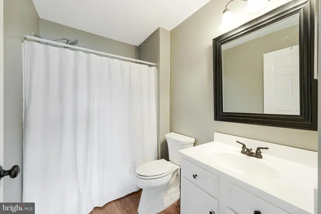 a bathroom with a toilet a sink and a mirror