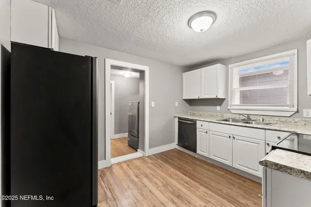 a kitchen with stainless steel appliances granite countertop a sink dishwasher a stove and a microwave oven with cabinets