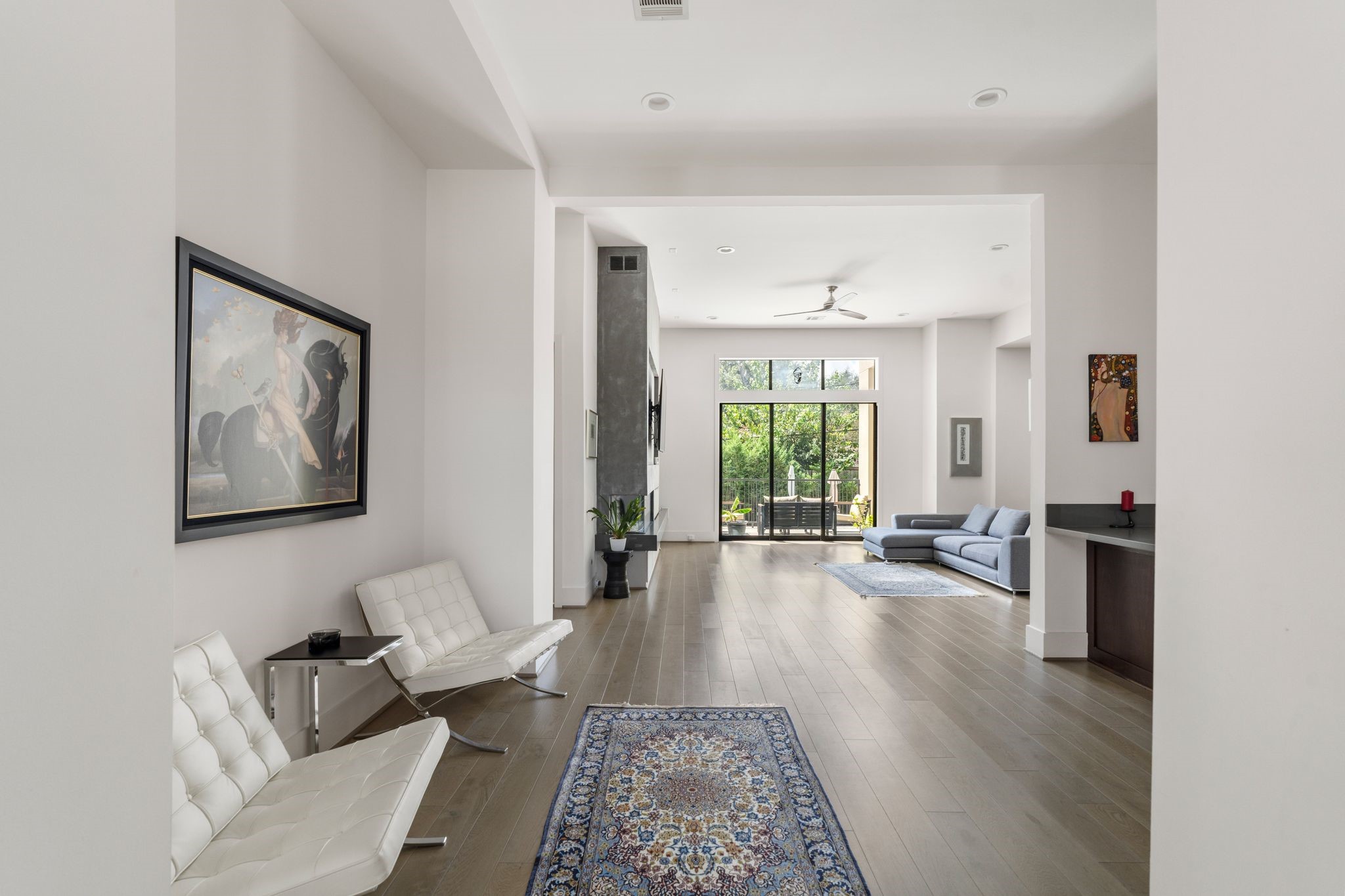5427 Maple Street Houston, TX 77096 - Photo 12 of 46 A wide sightline through the main living corridor connects the dining area to the family room, passing the wet bar and a glimpse of the fireplace wall ahead.