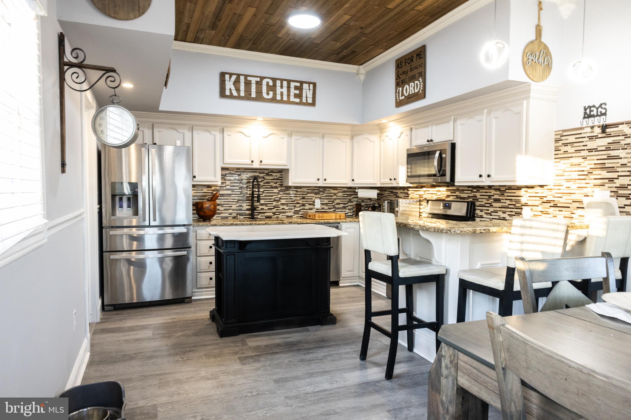 1476 South Orchard Road Vineland, NJ 08360 - Photo 9 of 37 a kitchen with stainless steel appliances kitchen island granite countertop a table chairs and a refrigerator