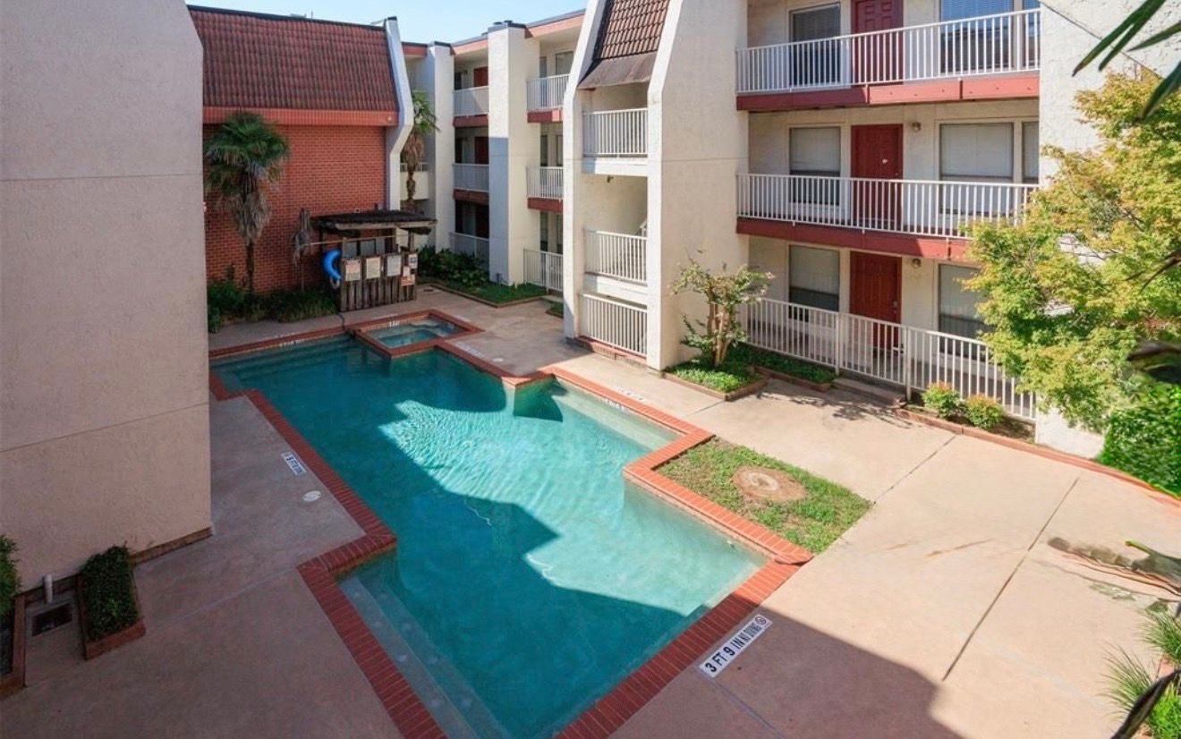 3115 Helms Street, Unit 111 Austin, TX 78705 - Photo 13 of 13 An inviting community pool and spa await, nestled among multi-story residences with private balconies.